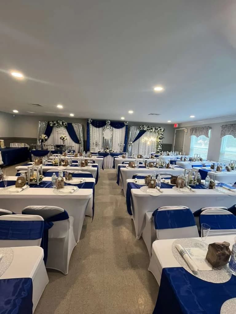 Reception hall with royal blue decor and premium table settings for Virginia event rental